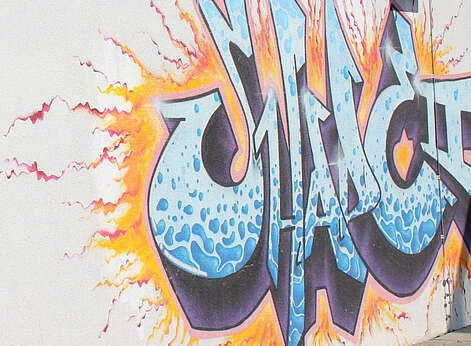 Buntes Graffitibild in blau und gelb an einer Hauswand