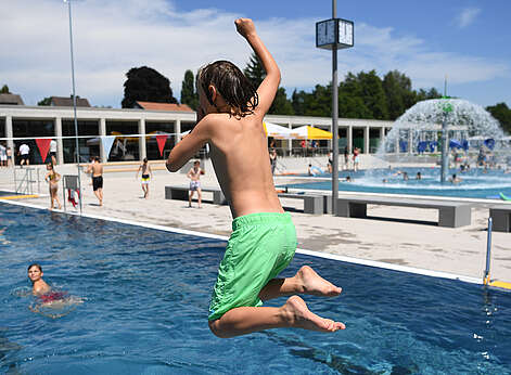Kind springt ins Wasser im Frei und Seebad Fischbach